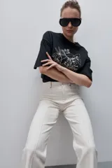 Pantalón de jean azul marino, de tiro alto y calce ajustado con pierna recta levemente amplia, bolsillos traseros y recortes verticales en el delantero.