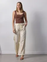 Pantalón palazzo color crudo de lyocell marca Nanette, con pretina elastizada, lazo de ajuste y bolsillos delanteros.
