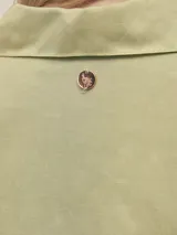 Camisa larga color crema confeccionada en lino-tencel con botones de conchas naturales y bolsillos laterales.