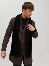 Bufanda de punto color negro, con diseño liso y etiqueta pequeña de la marca en el extremo.