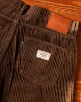 Pantalón de pana marrón con diseño de cinco bolsillos y corte clásico.
