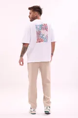 Remera color crudo de corte holgado con estampado pequeño en el frente.