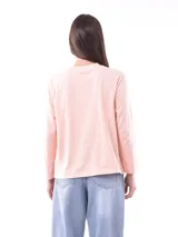 Remera de manga larga color beige, con cuello redondo y estampado frontal que dice "Magic is something you make" en color lila.