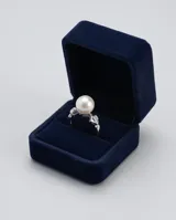Anillo de plata 925 con una perla central y un detalle de circonia engastada en el lateral.