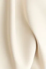 Vestido corto color beige, con escote en V pronunciado, tirantes finos ajustables, corte bajo el busto y falda acampanada con vuelo.