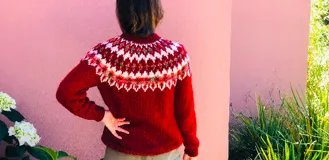 Sweater tejido a mano color mostaza con diseño geométrico en el canesú en tonos azul marino, blanco y verde.