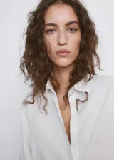 Camisa oversize blanca de lyocell, con mangas largas y cierre frontal de botones.