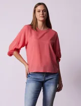 Blusa de gasa color salmón, con cuello redondo y mangas 3/4 amplias con elástico en los puños.