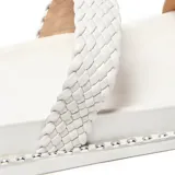 Sandalias blancas con plataforma baja, una tira delantera lisa y una tira ancha acolchada y trenzada en el empeine. Presentan borde con remaches plateados y suela lisa.