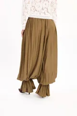 Pantalón negro de corte amplio, con cintura elástica fruncida y diseño abombacho con volados en los tobillos.