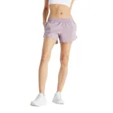 Short deportivo New Balance de dama, color lila, con cintura elástica y bolsillos laterales.