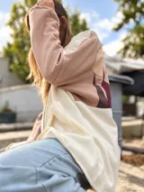 Campera con capucha de calce amplio, diseño en bloques de color beige, rosado y marrón, con aplique textil en la espalda que simula un paisaje montañoso. Cuenta con cierre delantero y bolsillos.