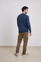 Sweater verde con cuello redondo y tres botones.