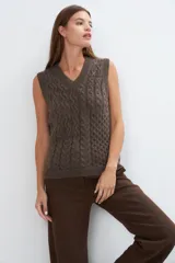 Chaleco tejido marrón con escote en v y sisas amplias. Diseño con diferentes puntos combinados en el frente.