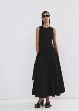 Falda midi negra de corte evasé, tiro medio, con cintura elástica y lazo lateral.