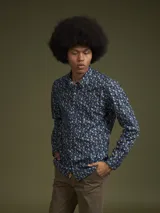 Camisa de hombre azul marino con estampado floral en tonos celeste y amarillo, de manga larga y corte clásico.