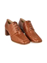 Zapato acordonado tipo oxford con taco cuadrado de madera, confeccionado en cuero con textura de reptil en color suela.