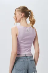 Musculosa corta negra sin mangas, de corte asimétrico frontal y ceñida al cuerpo.