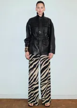 Pantalón largo de viscosa con estampado animal print tipo cebra en tonos beige y negro, de corte recto y holgado.