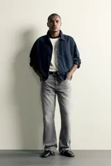 Jeans flare fit de denim de algodón en color celeste con lavado efecto desgastado. Presentan diseño de cinco bolsillos, tiro medio, cierre frontal con cremallera y botón, y bajo con acabado irregular.