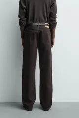 Jeans flare fit de denim negro, con tiro medio, corte ajustado en la parte superior y ligeramente acampanado desde la rodilla. Diseño de cinco bolsillos y cierre frontal con botones.
