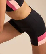 Bermuda deportiva Get Over de talle alto, color negro, con bandas laterales en tonos rosado y salmón, confeccionada en poliamida y elastano.