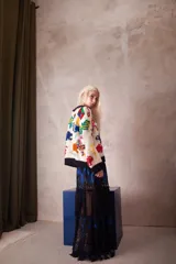 Sweater de lana tejido y bordado a mano, de calce holgado con cuello a la base y puños. Presenta un diseño de figuras coloridas sobre una base de color crudo.