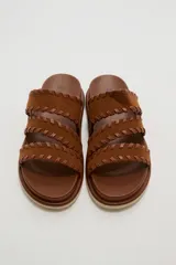Sandalias planas color negro con tres tiras anchas adornadas con costuras cruzadas en el borde.