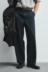 Pantalón de corte balloon fit confeccionado en una mezcla de lyocell y algodón. Presenta cierre frontal con cremallera y botón, bolsillos laterales y bolsillos traseros de vivo.