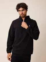 Sweater de polar negro con cuello alto y cierre frontal parcial. Presenta mangas largas con puños elásticos y un pequeño logo bordado en el pecho.
