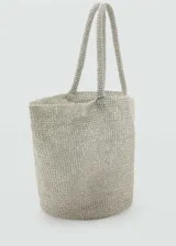Bolso tipo shopper de tamaño grande, confeccionado en tejido de malla con acabado metalizado color plateado. Presenta doble asa corta y diseño abierto sin cierre.