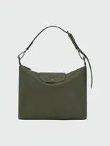 Cartera tipo hobo de tamaño grande, confeccionada en cuero vacuno con acabado liso. Presenta una solapa frontal con cierre de broche a presión y logo grabado, correa de hombro ajustable y herrajes metálicos.