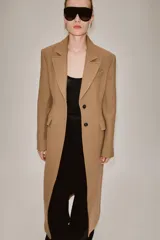 Abrigo largo entallado de Zara Woman Collection, confeccionado en mezcla de lana color tostado. Presenta cuello con solapa de muesca, mangas largas, bolsillos con solapa en el frente, forro interior y cierre frontal de dos botones oscuros.