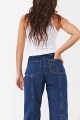 Pantalón de jean estilo slouchy en color azul oscuro, con costuras verticales decorativas en el frente y corte holgado.