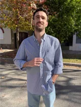 Camisa de hombre de algodón con estampado a cuadros en tonos rosado y celeste, corte clásico, manga larga, bolsillo en el pecho y botón en el cuello.