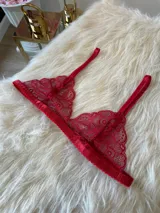 Conjunto de lencería compuesto por un bralette triangular de encaje con breteles regulables y una tanga de encaje regulable con corte media less.