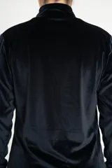 Buzo de cuello alto confeccionado en tela de terciopelo negro, de manga larga y corte holgado con puños y ruedo ajustados.