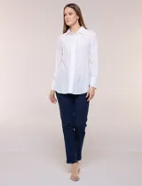 Camisa de calce relajado color celeste, confeccionada en tejido de textura suave y fluida. Presenta cuello camisero y abotonadura frontal, mangas largas con puño ancho y ruedo curvo.