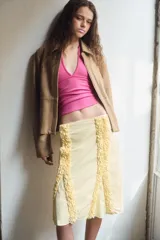 Blazer de cuero color beige con cuello solapa, manga larga y cierre frontal con cremallera y botones a presión ocultos. Presenta bolsillos laterales ocultos en costura y forro interior.
