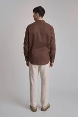 Camisa de lino color marrón, con cuello mao, manga larga y botones blancos.