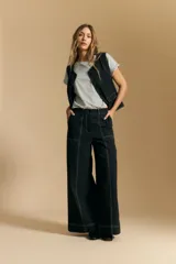 Pantalón ancho de tiro alto, color negro, con costuras contrastantes en blanco que definen los bolsillos y los bordes.