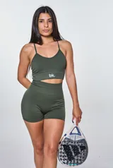 Conjunto deportivo de dos piezas en color verde militar, compuesto por un top corto de tirantes finos con logo estampado y un short de tiro alto ajustado. Ambas prendas presentan una textura acanalada.