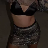 Minifalda de malla metálica con incrustaciones de cristales brillantes y cintura elástica negra.
