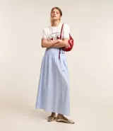 Cartera tipo shoulder bag de diseño media luna, confeccionada en poliuretano con acabado brillante. Presenta detalles frontales estilo gota, cierre superior por cremallera y correa de hombro ajustable con ojetes metálicos.