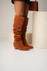 Bota de cuero color marrón, de caña alta arrugada, con punta fina y taco de madera.