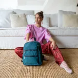 Mochila rosa de tafeta con apertura superior con cierre y tiradores metálicos, bolsillos internos, bolsillo con doble cierre metálico al frente, asas rígidas de mano y correas regulables para colgar en la espalda.