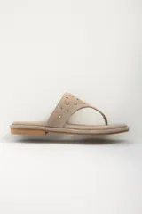 Sandalias de cuero color beige con apliques metálicos redondos.