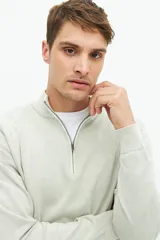 Buzo azul marino de tejido de punto con cuello alto y medio cierre con cremallera.