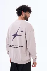 Buzo de felpa oversize con cuello redondo, diseño de estrellas y texto estampado en la espalda, confeccionado en mezcla de algodón y poliéster.