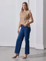 Blusa color beige con textura acanalada, cuello alto con detalle de crochet y volados en los hombros.